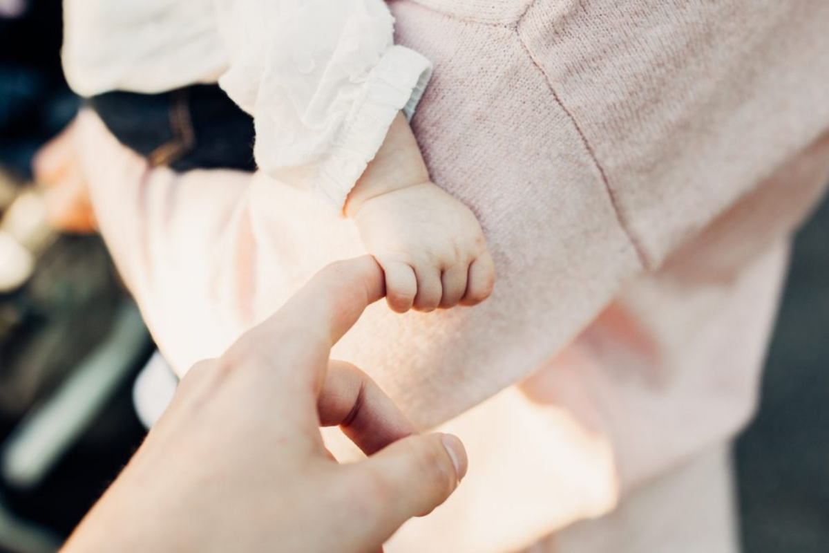 Fotografía de la mano de un bebé agarrando un dedo de su madre